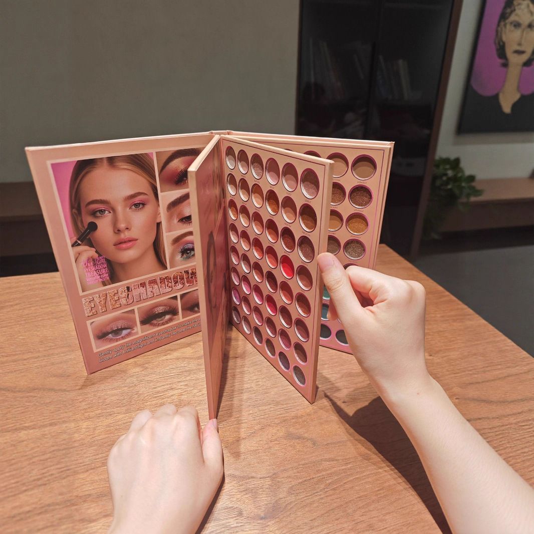 A rose gold makeup palette with multiple circular eyeshadow pans is shown open on a wooden table, with a person's hands holding it. The front cover features a model photo and Chinese text.