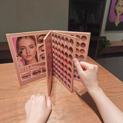 A rose gold makeup palette with multiple circular eyeshadow pans is shown open on a wooden table, with a person's hands holding it. The front cover features a model photo and Chinese text.