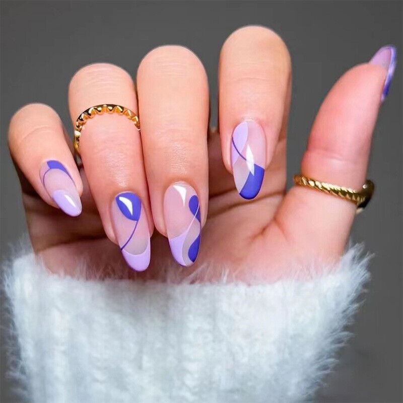 Hand with purple and white nail design wearing gold rings on a gray background