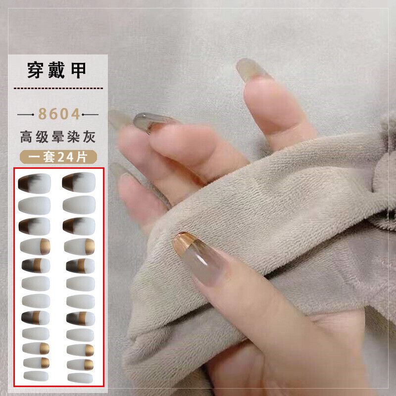 A hand wearing a set of long, nude-toned press-on nails, with a beige towel covering part of the hand. A text panel on the left shows the product name in Chinese, style number 8604, and a grid of the nail shapes and colors included in the set of 24 pieces.