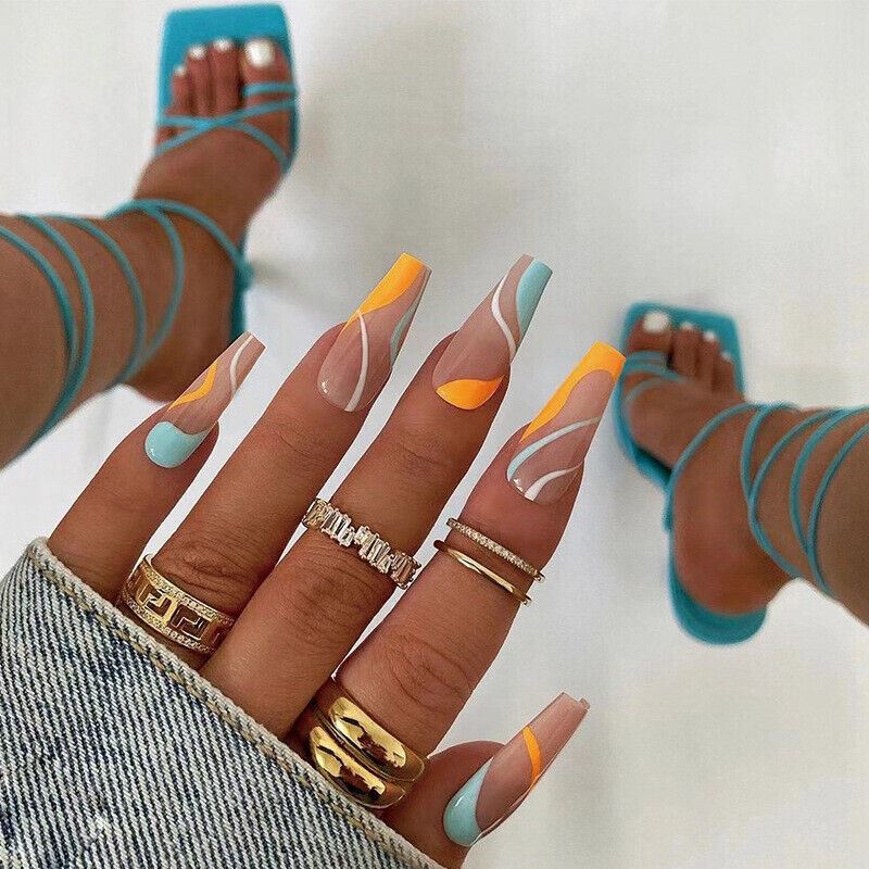 Hand with colorful nail art and turquoise sandals on a white background