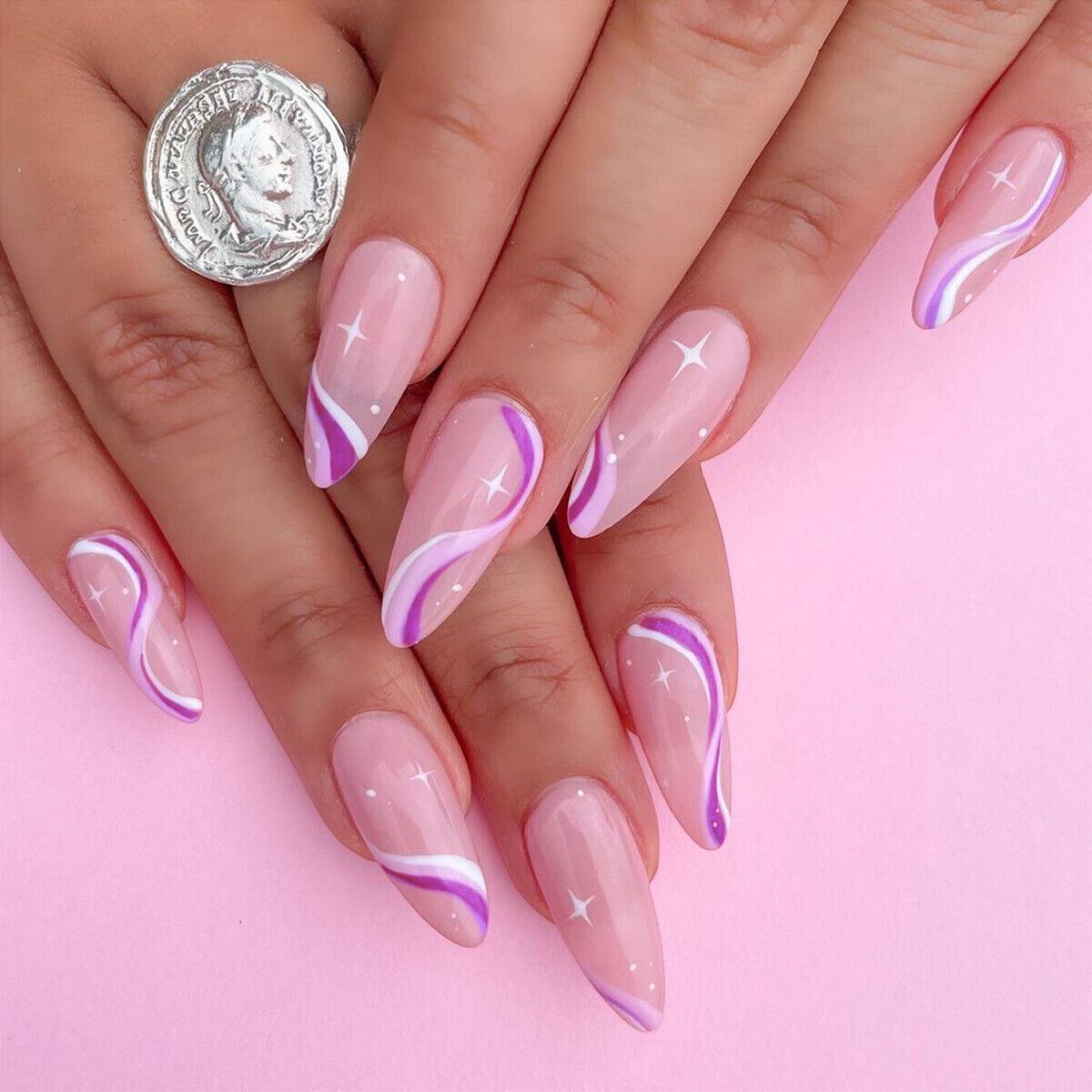 Nails with pink and purple design on a pink background