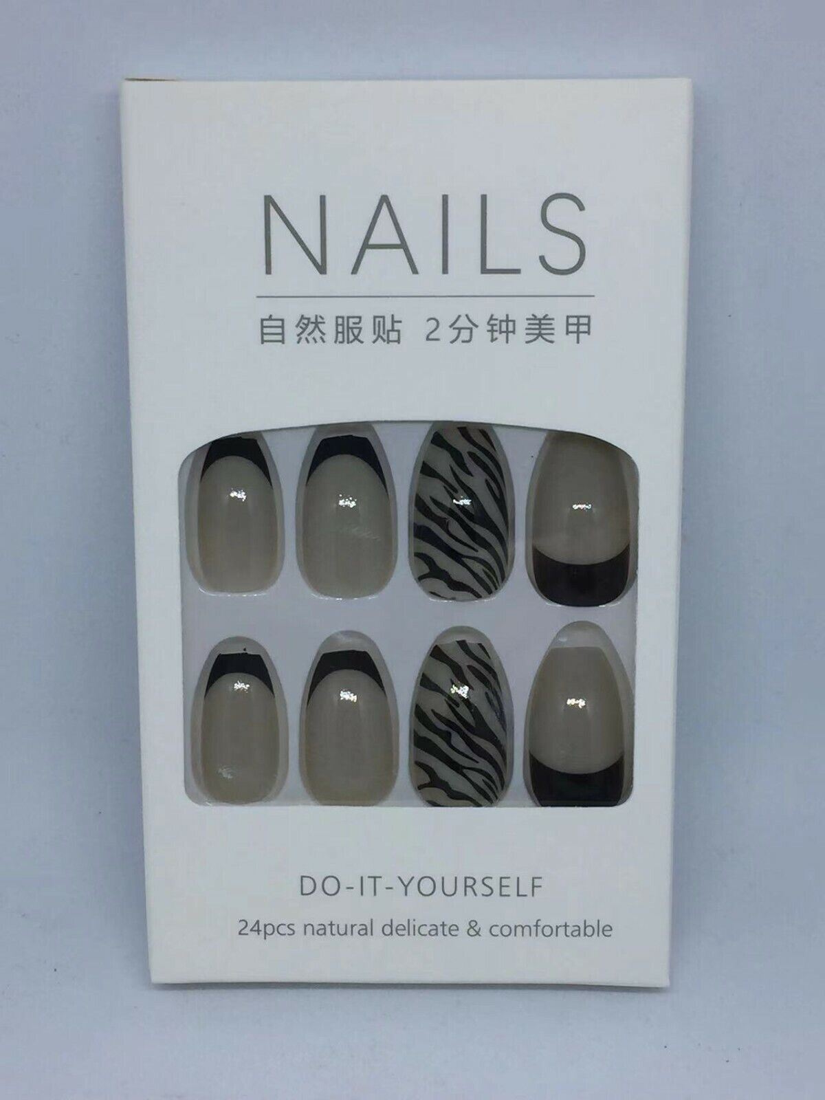 A white retail box containing a set of press-on nails. The box has a clear window showing eight almond-shaped nails with neutral designs: three are solid taupe-beige, three are black and white zebra stripes, and three are solid black French tips.