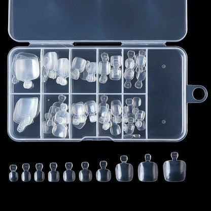 A set of clear press-on false nails in multiple sizes, displayed inside an open transparent storage case with additional nails aligned below on a black background.