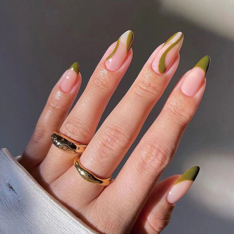 Hand with green and pink nail design wearing gold rings on a neutral background