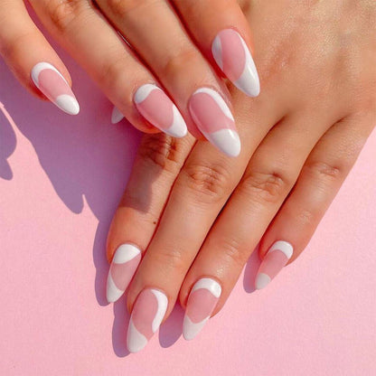 Close-up of hands with pink and white nail polish on a pink background