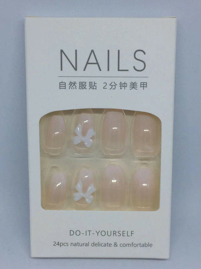 Pack of 24 natural press-on nails in a white box with a clear window showing the nude-colored nails, two decorated with small white bow designs.