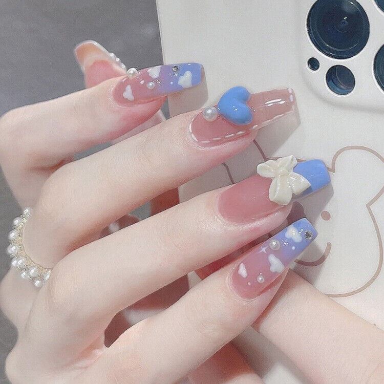 Close-up of a hand with pastel nail art holding a phone.