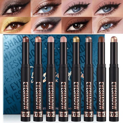 Six STIC eyeshadow sticks displayed in front of their blue patterned packaging, with a grid of eight close-up eye makeup swatches across the top showing different eyeshadow looks.