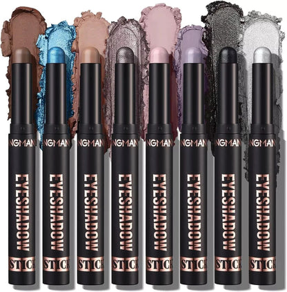 Set of eight eyeshadow sticks with swatches on a white background