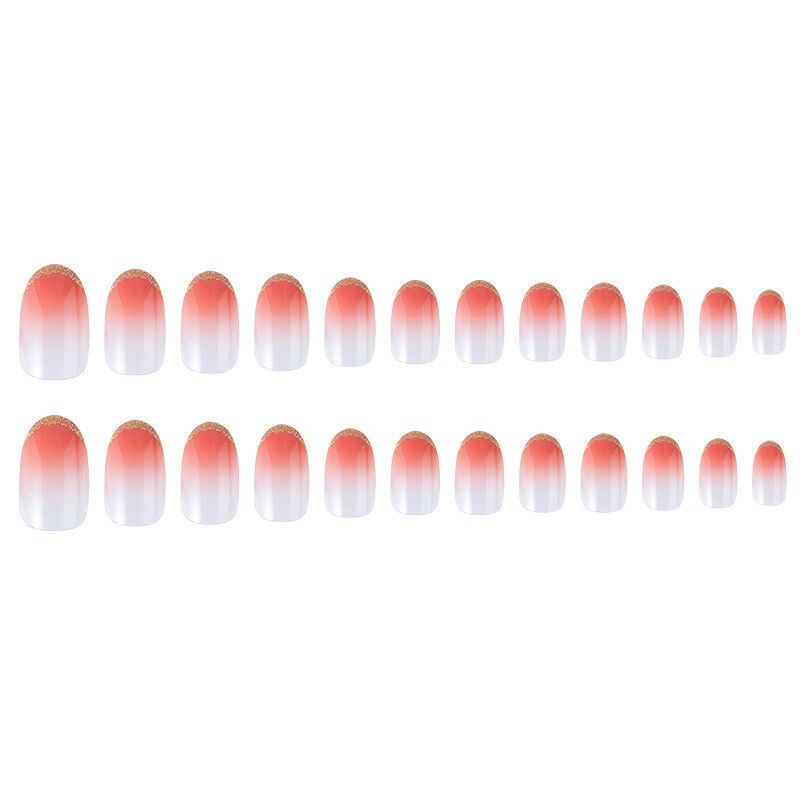 Two rows of oval press-on nails with a coral-pink to white ombre gradient and a small gold glitter accent at the tips, shown on a plain white background.