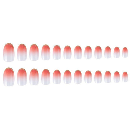 Two rows of oval press-on nails with a coral-pink to white ombre gradient and a small gold glitter accent at the tips, shown on a plain white background.