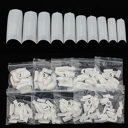 White artificial nail tips arranged in a row above clear plastic bags labeled 1 through 10, showing different lengths and shapes of nail extensions on a black background.