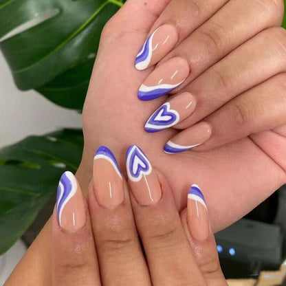 Nails with heart and wavy design in blue and white on a neutral background