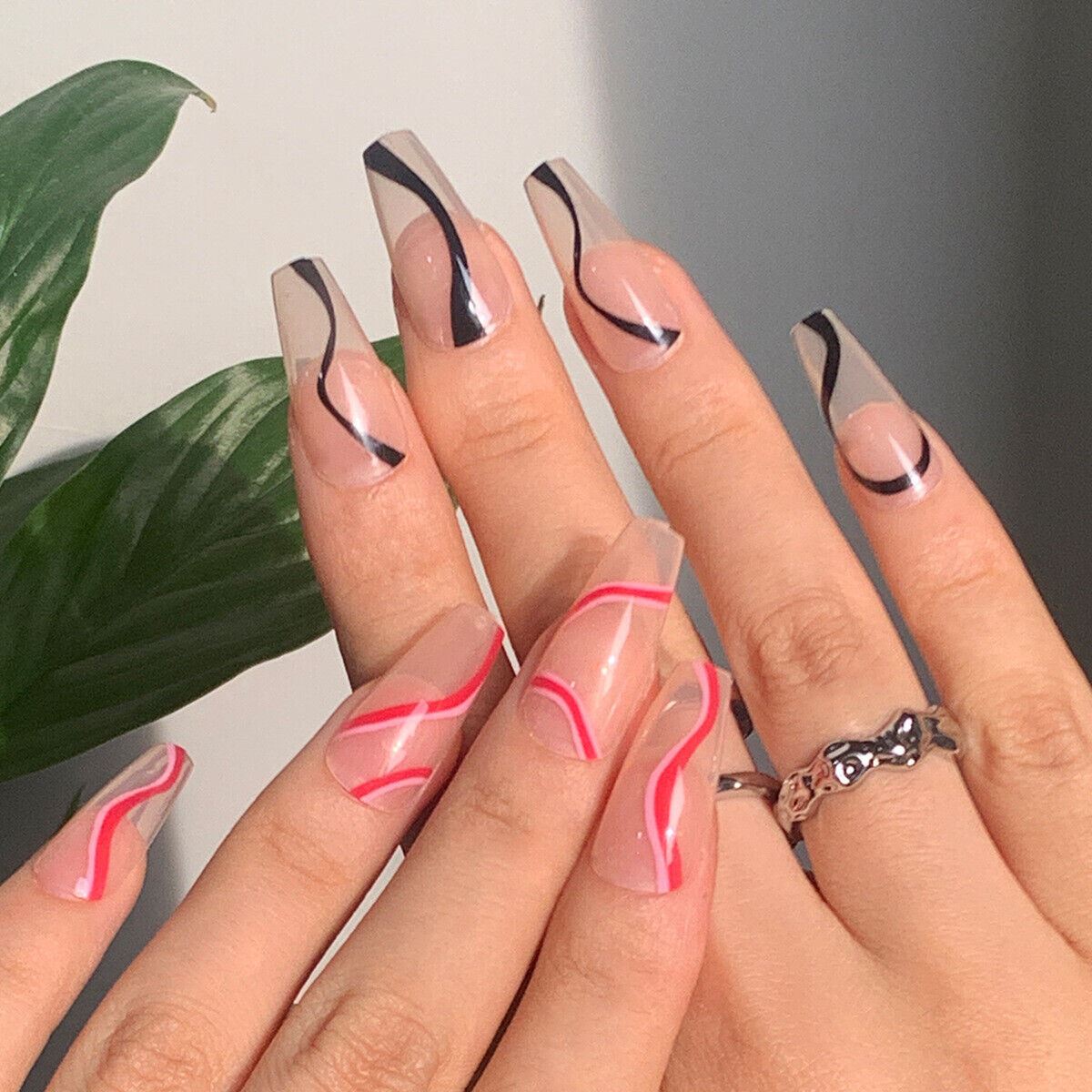 Nails with wavy line designs on a neutral background