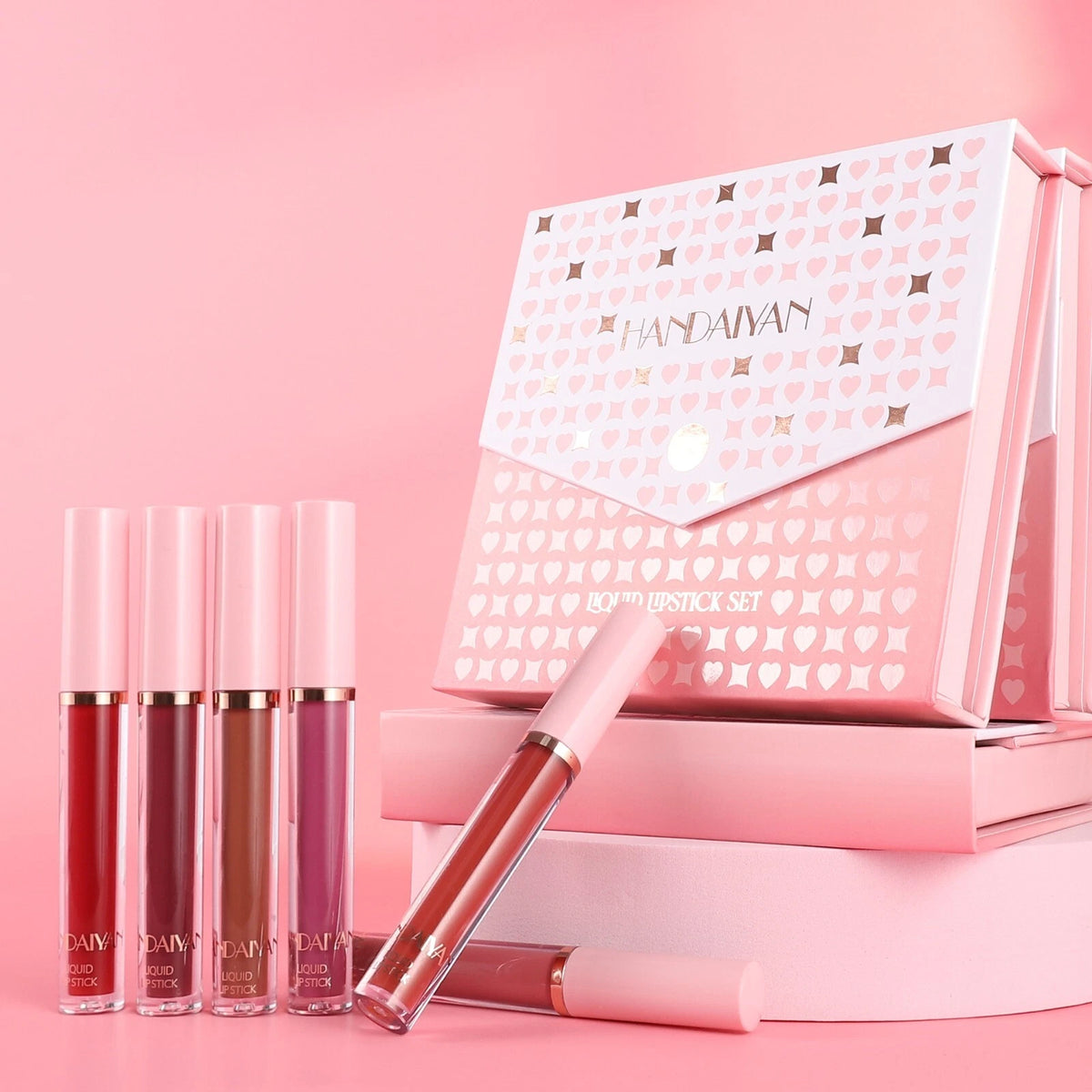 Set of lip glosses and a pink box with 'HANDAIYAN' branding on a pink background