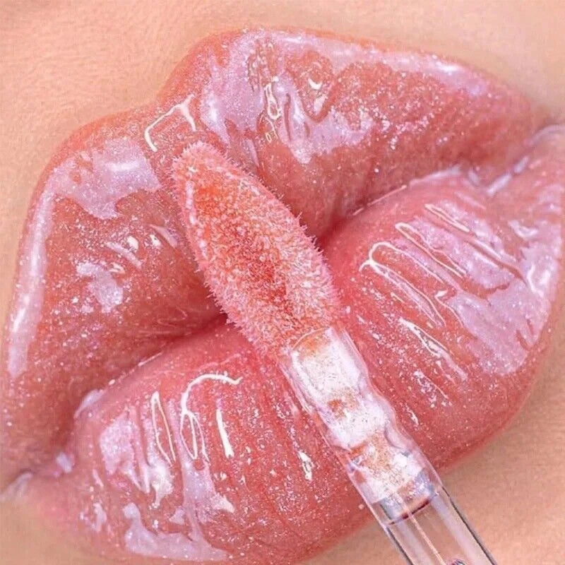 Close-up of a lip with a lip gloss applicator on a beige background