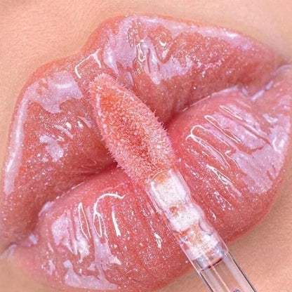 Close-up of a lip with a lip gloss applicator on a beige background