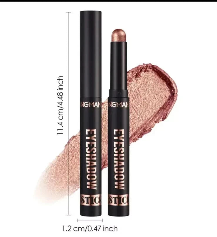 Two black NGHAI STIC eyeshadow sticks shown on a white background with a swatch of the shimmering rose-gold eyeshadow behind them. Measurement labels indicate 11.
